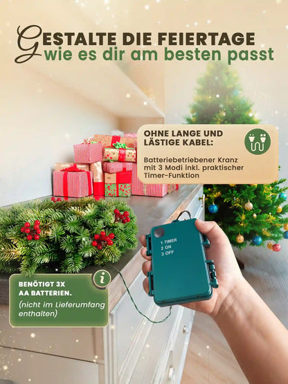 Kerstkrans op batterijen van ArtiTree met timerfunctie – hand houdt de bediening vast, krans ligt op een ladekast